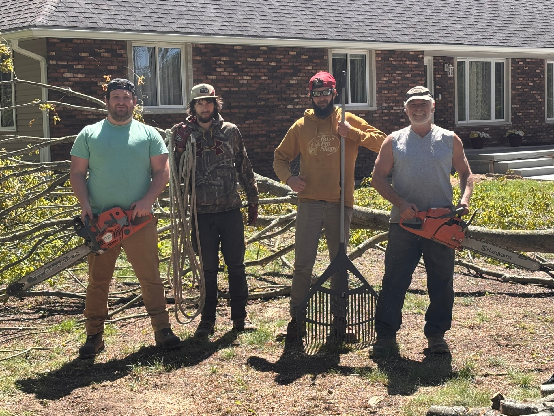 TNT Tree Services crew with chainsaws and rope after a tree removal job in Lapeer County, MI