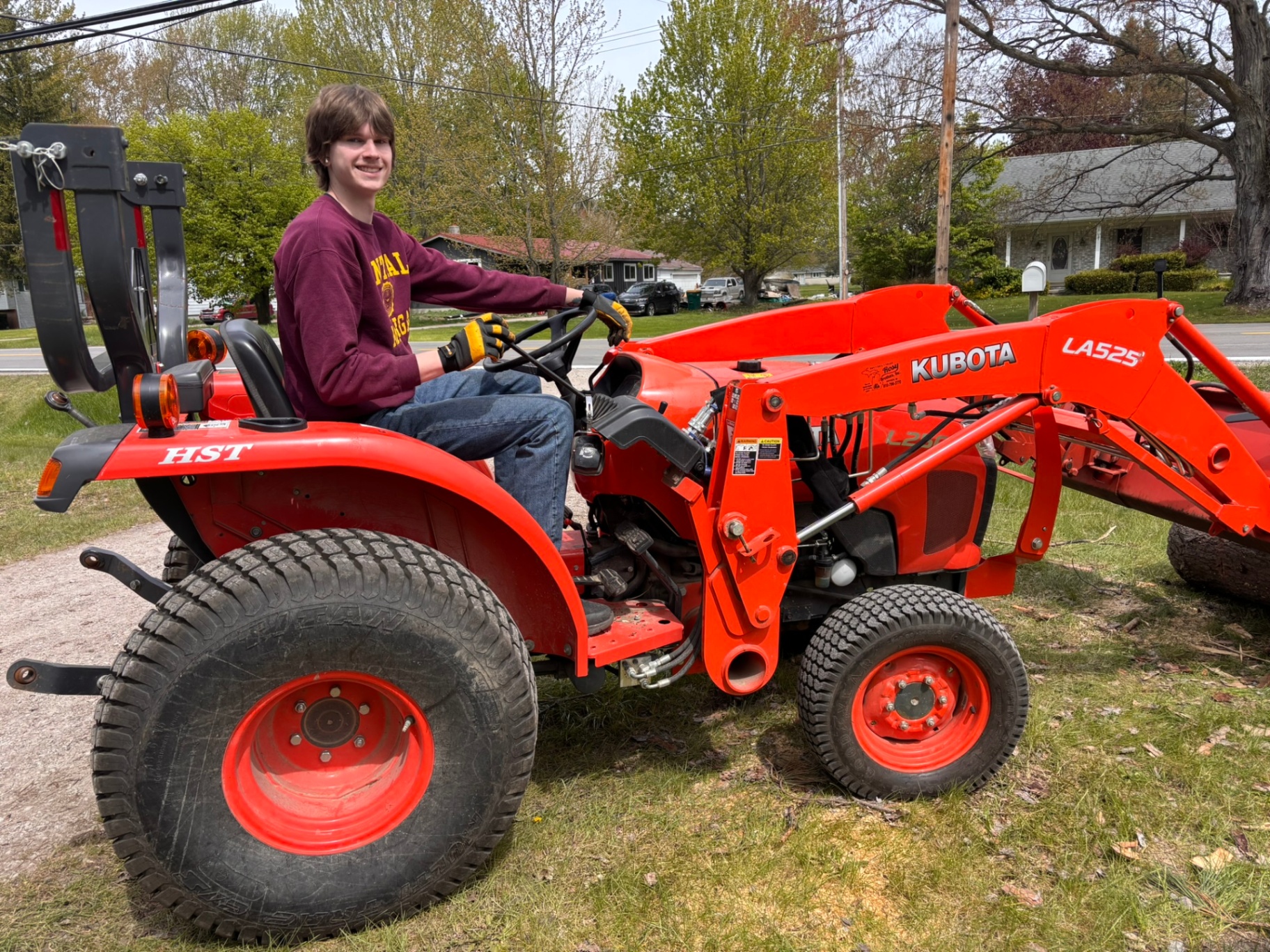 TNT crew member operating a Kubota tractor for storm debris cleanup